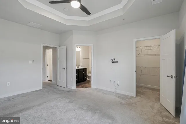 an empty room with closet and a chandelier fan