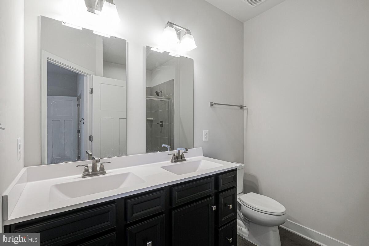 14934 Ring House Road Brandywine, MD 20613 - Photo 24 of 34 a bathroom with a double vanity sink toilet and a mirror