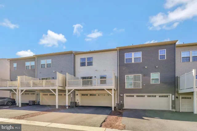 a front view of multiple houses with a street