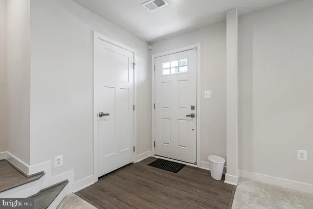 an empty room with wooden floor and closet