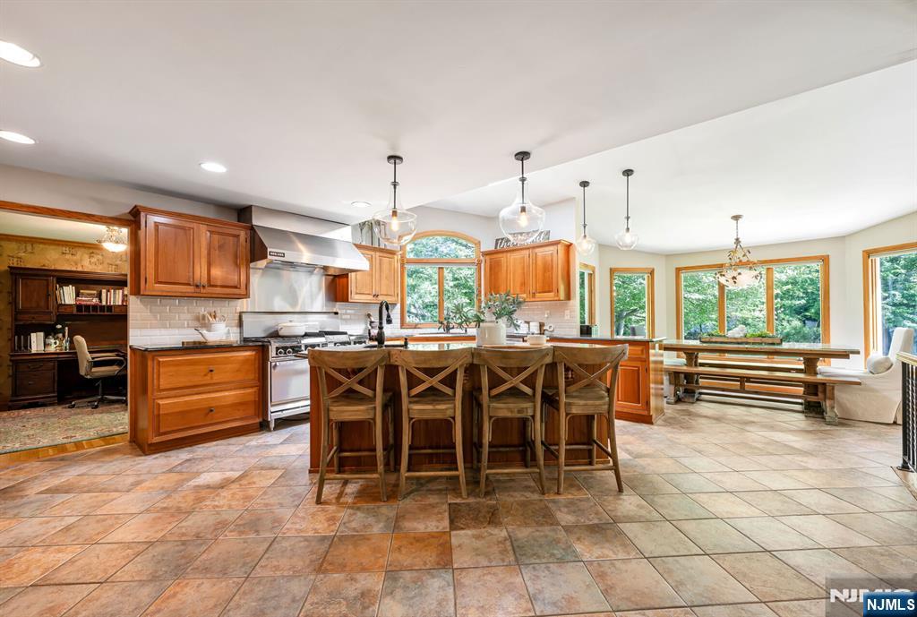 411 Snyder Road Wyckoff, NJ 07481 - Photo 7 of 36 a kitchen with stainless steel appliances kitchen island granite countertop a table and chairs in it