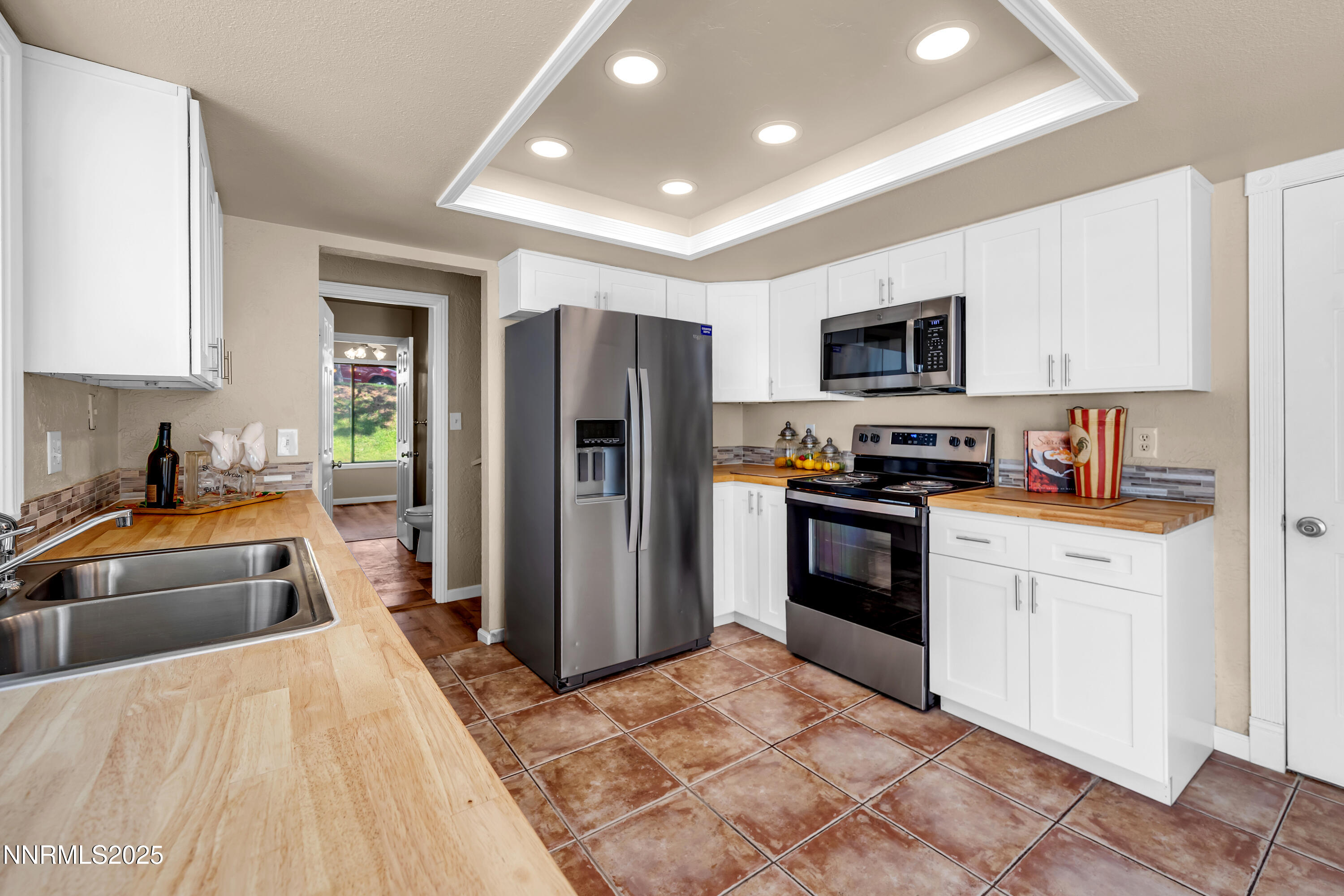 1265 Searchlite Court Reno, NV 89503 - Photo 13 of 43 a kitchen with refrigerator a microwave a sink and cabinets