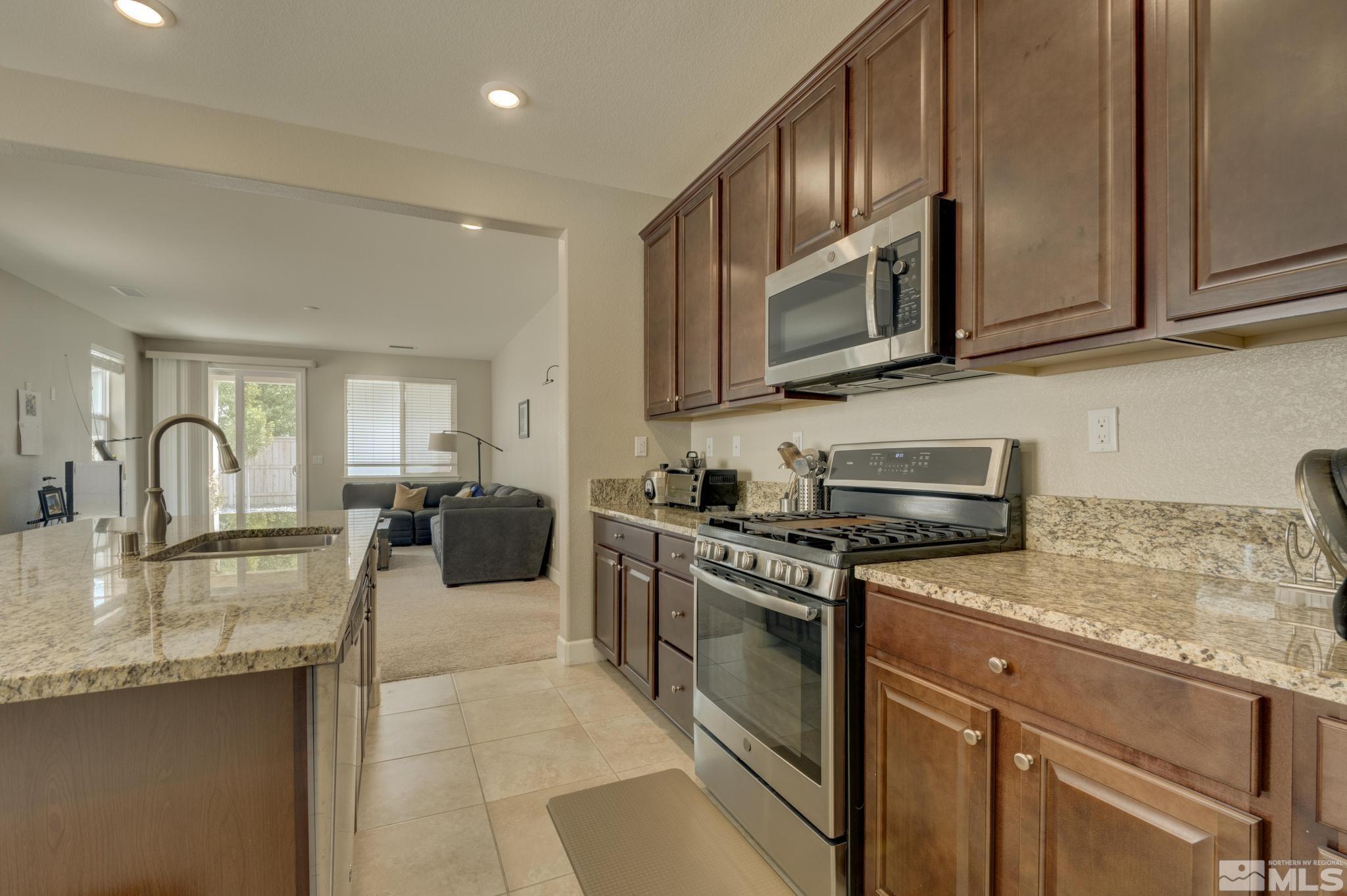 10180 Culiacan Pass Trail Reno, NV 89521 - Photo 6 of 34 a kitchen with stainless steel appliances granite countertop a stove a sink and a microwave