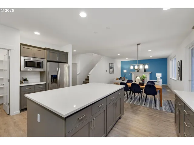 a kitchen with a dining table chairs and refrigerator