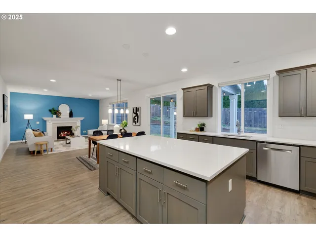a view of kitchen island a sink wooden floor and living room view