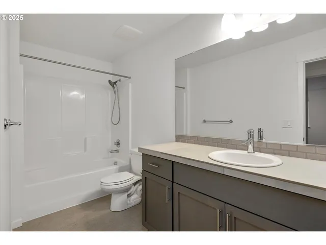 a bathroom with a granite countertop sink toilet a large mirror and shower