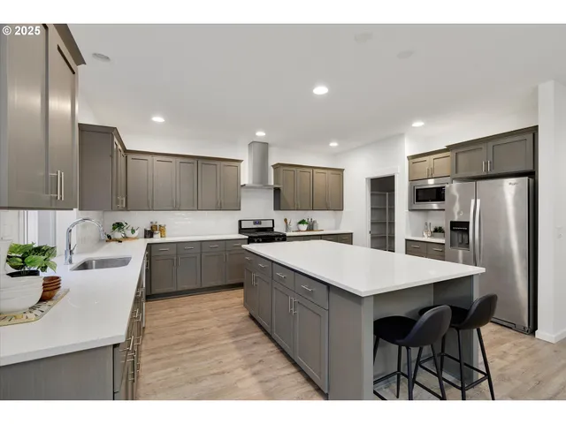 a large kitchen with kitchen island a sink table and chairs