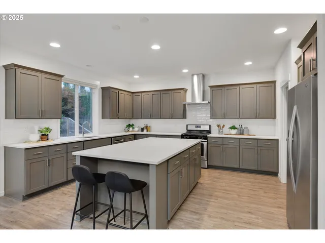 a kitchen with a sink a counter top space stainless steel appliances and cabinets