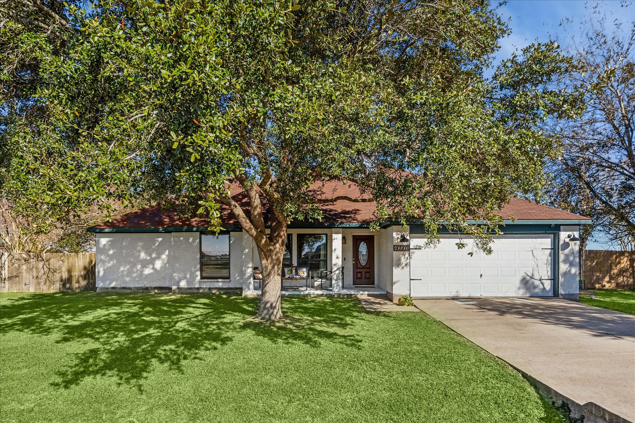 10503 Alex Drive front elevation with beautiful shade tree, and painted brick exterior.