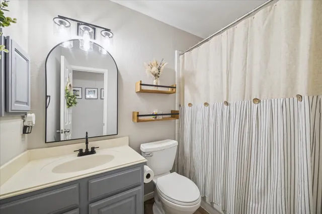 a bathroom with a toilet a sink and a mirror
