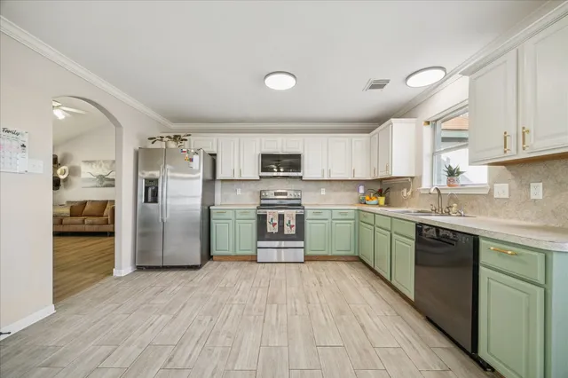 a kitchen with granite countertop a refrigerator stove top oven and sink