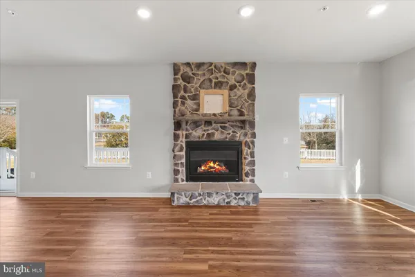 a kitchen with stainless steel appliances granite countertop a refrigerator a sink dishwasher a stove and white countertops with wooden floor