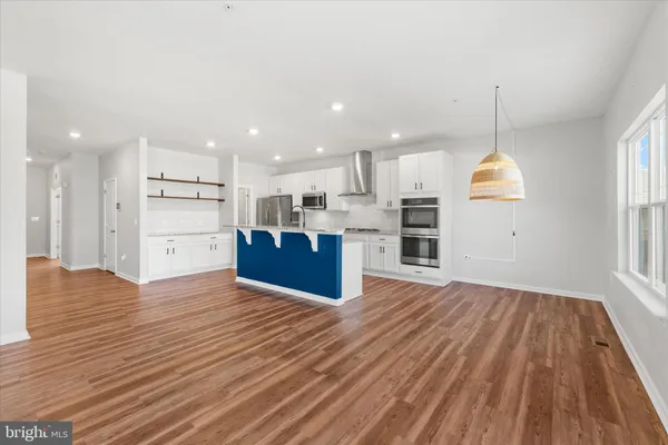 a kitchen with stainless steel appliances granite countertop a refrigerator a sink dishwasher a stove with wooden floor and cabinets