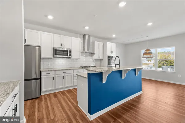 a kitchen with stainless steel appliances granite countertop a stove a sink and a refrigerator