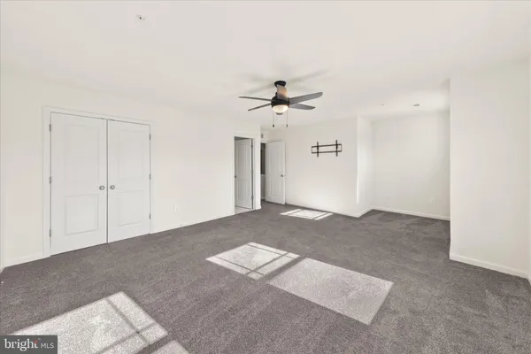 a view of a livingroom with a ceiling fan and window