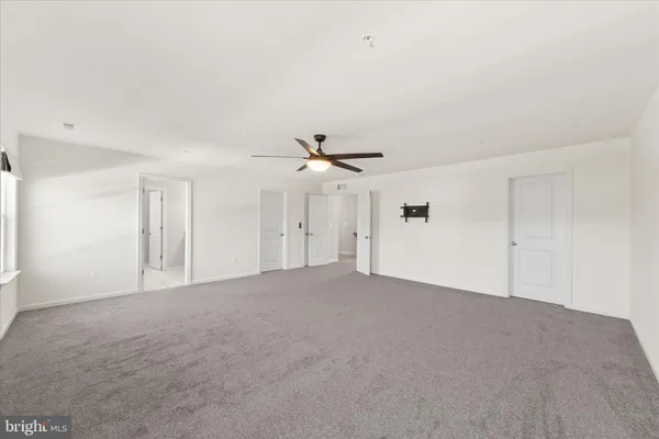 a bedroom with a large bed chandelier and a window