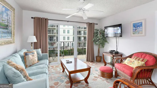 a living room with furniture a flat screen tv and a potted plant