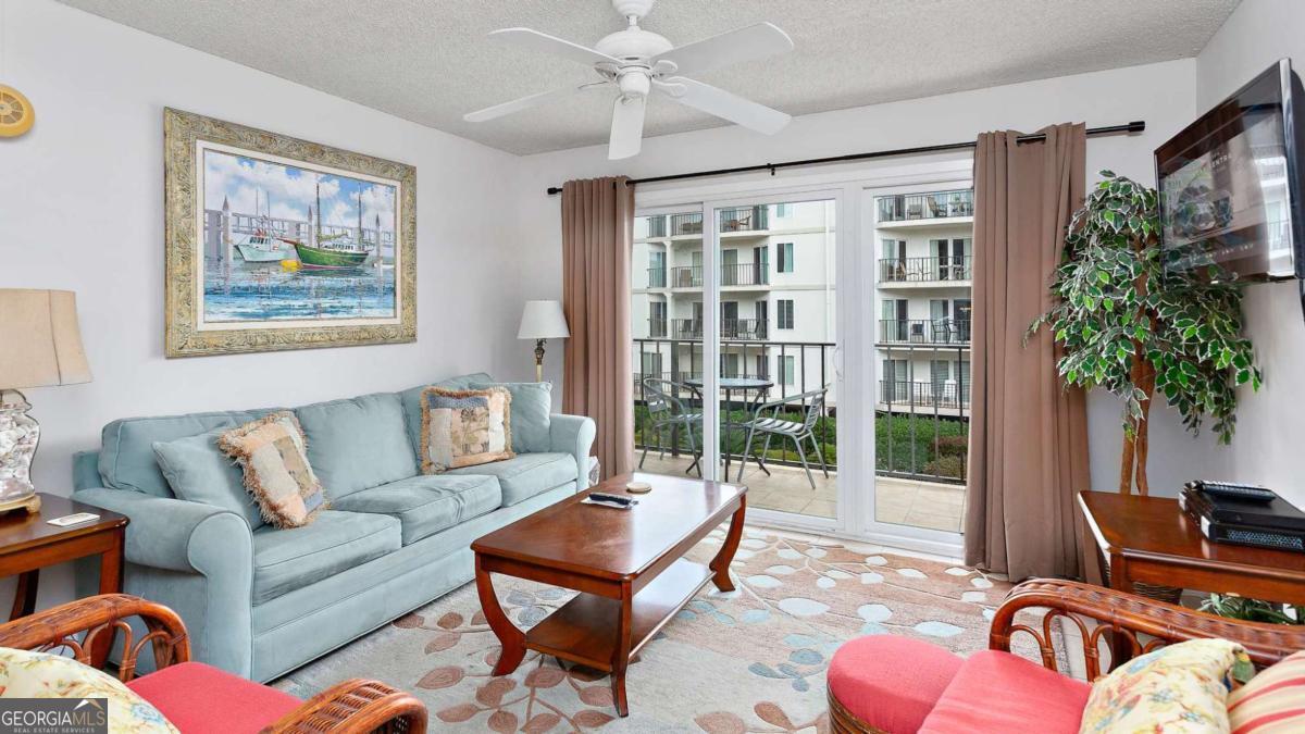 1440 Ocean Boulevard, Unit 224 St. Simons, GA 31522 - Photo 6 of 26 a living room with furniture a flat screen tv and a potted plant