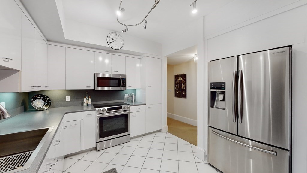 206 Allandale Road, Unit 2D Boston, MA 02467 - Photo 16 of 39 a kitchen with a refrigerator a microwave and cabinets