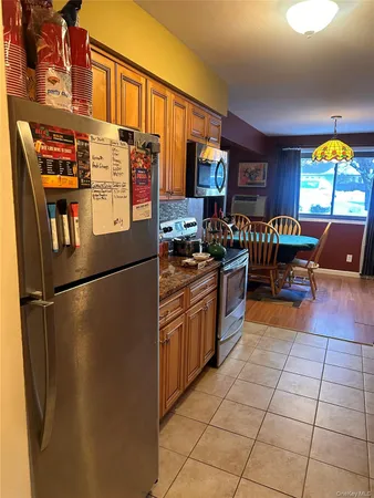 a kitchen with stainless steel appliances granite countertop a refrigerator a stove a sink and a microwave