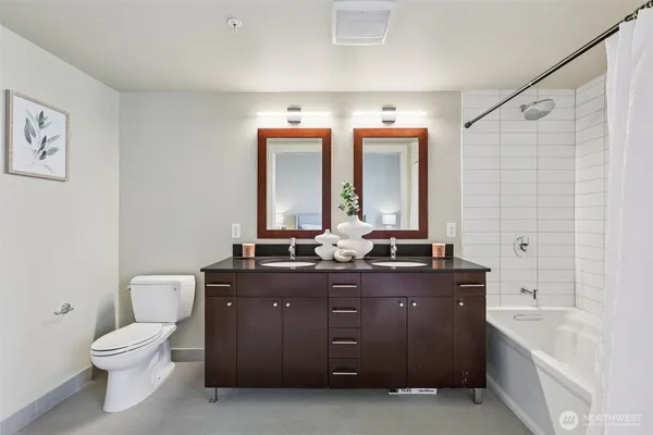 a spacious bathroom with a granite countertop sink a toilet and a bathtub