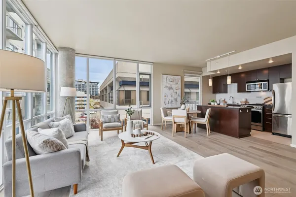 a living room with furniture kitchen view and a large window