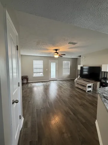 a view of a livingroom with wooden floor and furniture