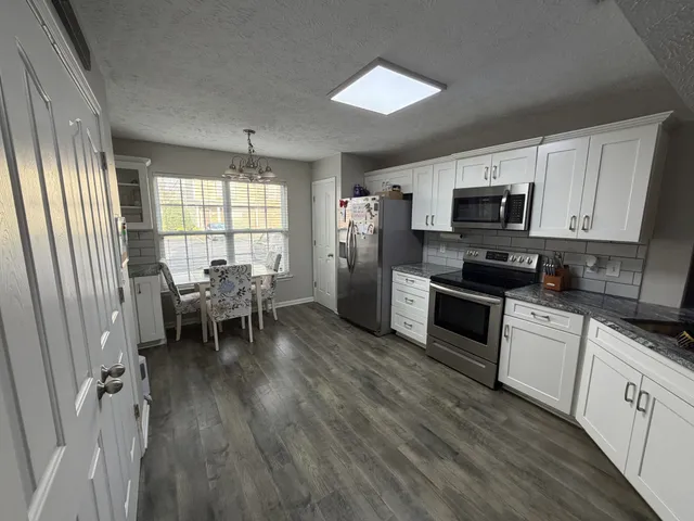 a view of a kitchen with wooden floor and a refrigerator