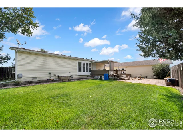 a view of a backyard with table and chairs plants and a barbeque