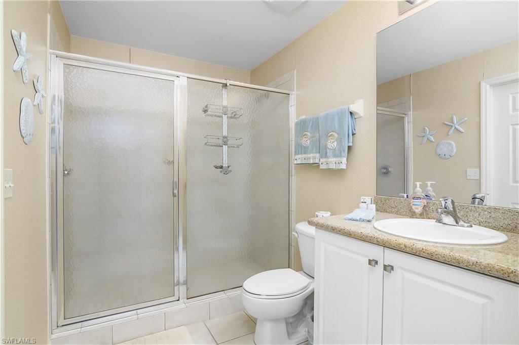 7930 Mahogany Run Lane, Unit 814 Naples, FL 34113 - Photo 8 of 33 a bathroom with a shower sink vanity mirror and toilet