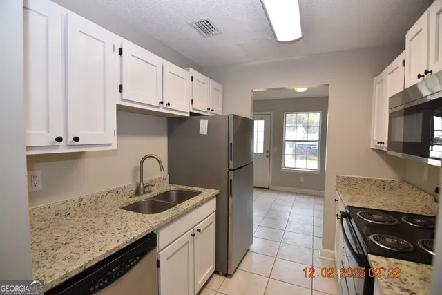 a kitchen with stainless steel appliances granite countertop a sink stove and cabinets
