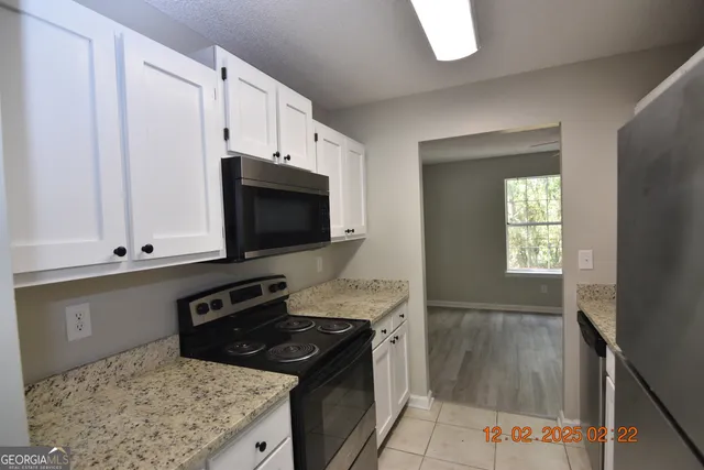 a kitchen with stainless steel appliances granite countertop a stove microwave and sink