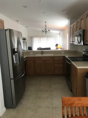 a kitchen with stainless steel appliances granite countertop a refrigerator and a sink