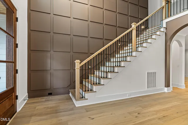 a view of a hallway with wooden floor and staircase