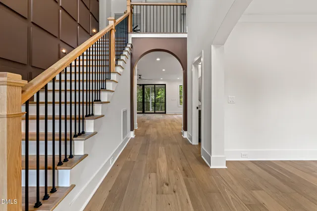 a view of staircase with wooden floor and white walls