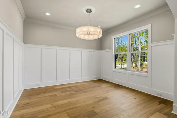 a kitchen with stainless steel appliances granite countertop a sink a microwave a refrigerator and wooden floors