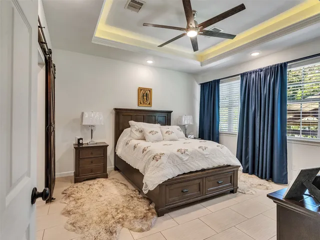 a spacious bedroom with a bed and a chandelier