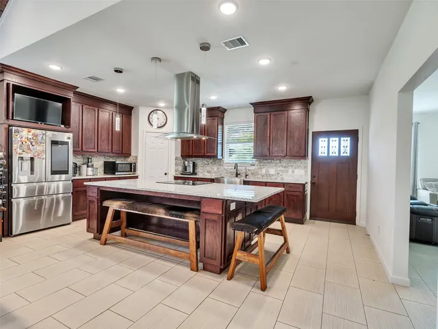 a open kitchen with stainless steel appliances granite countertop a stove refrigerator and cabinets