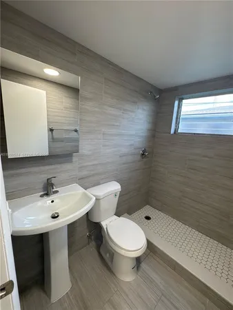 a bathroom with a sink mirror and toilet