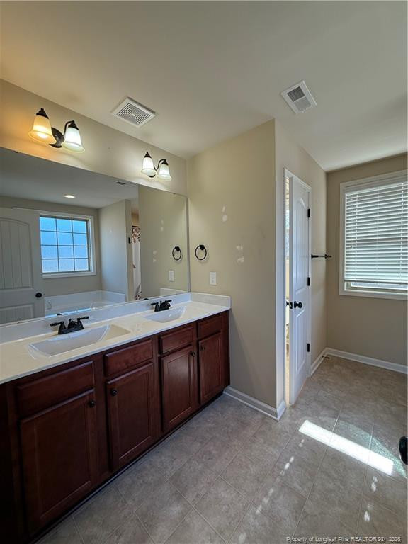 22 Raintree Lane Spring Lake, NC 28390 - Photo 20 of 25 a spacious bathroom with a double vanity sink a large mirror and a bathtub