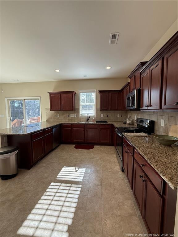 22 Raintree Lane Spring Lake, NC 28390 - Photo 5 of 25 a large kitchen with stainless steel appliances granite countertop a stove top oven a sink dishwasher a dining table and chairs with wooden floor