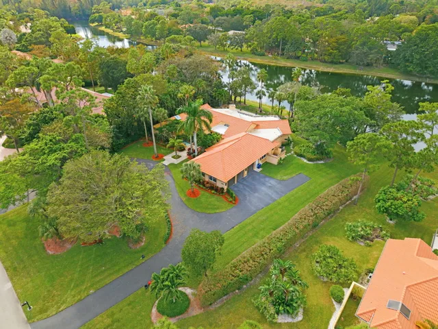 an aerial view of a house with a yard and lake view