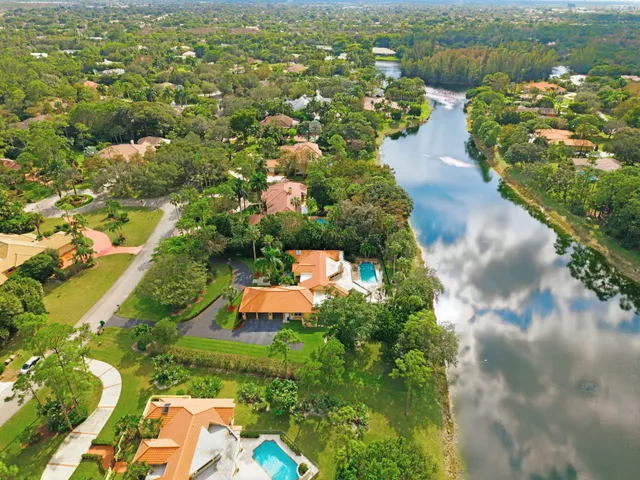 an aerial view of residential houses with outdoor space and trees all around