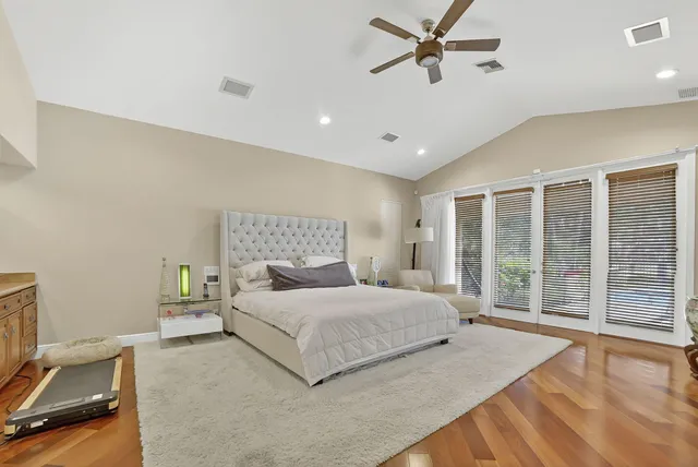 a spacious bedroom with a large bed and a chandelier
