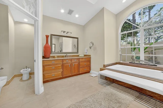 a spacious bedroom with a large bed and a chandelier