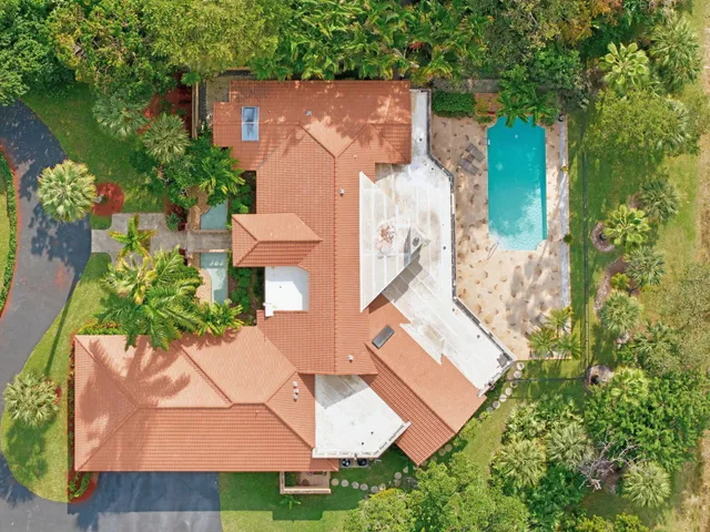 an aerial view of a house with a yard swimming pool and outdoor seating