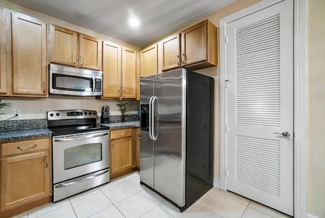 a kitchen with stainless steel appliances granite countertop a refrigerator stove and microwave