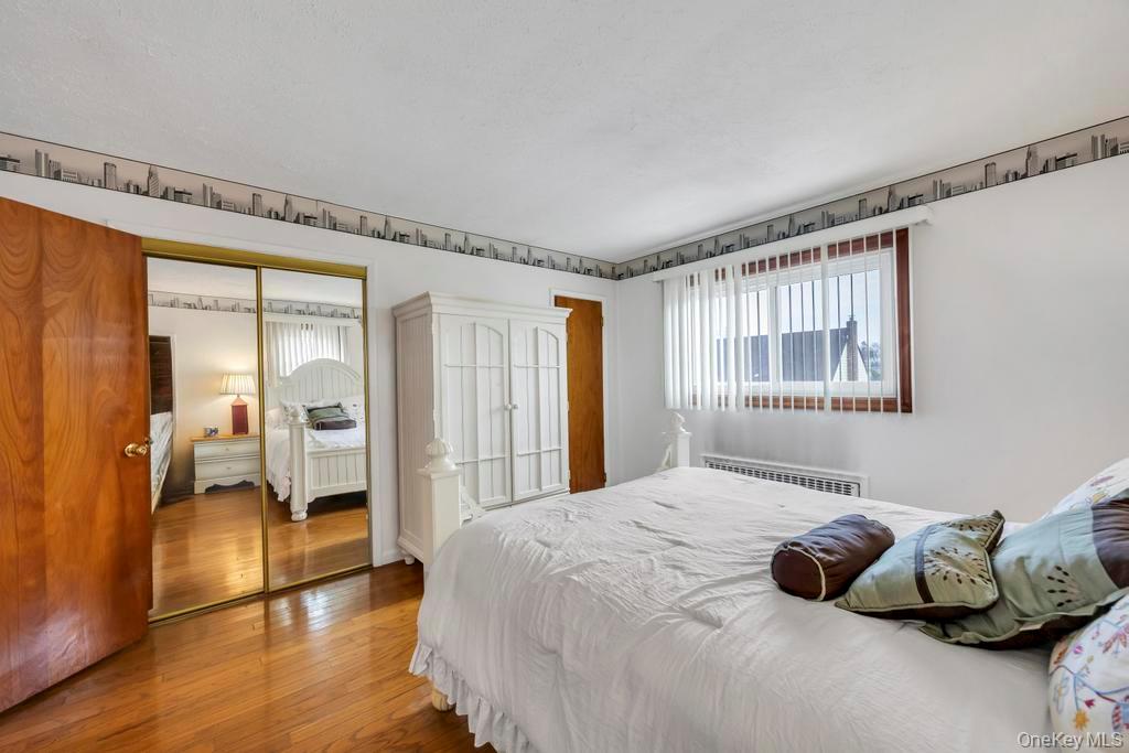 7 North Terrace Place Valley Stream, NY 11580 - Photo 22 of 40 a bedroom with a bed and wooden floor