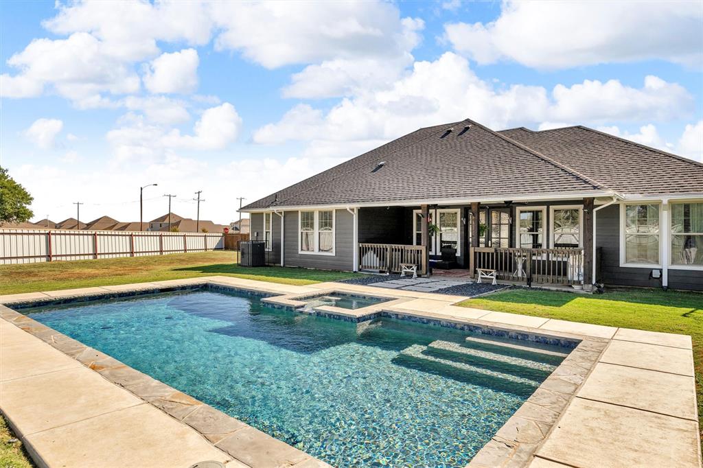 a view of swimming pool with lawn chairs and large trees