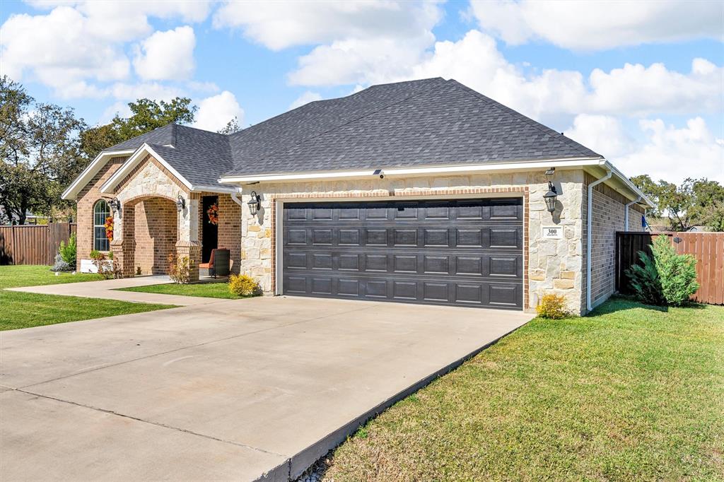 300 West Bell Street Everman, TX 76140 - Photo 2 of 28 a front view of a house with a yard and garage